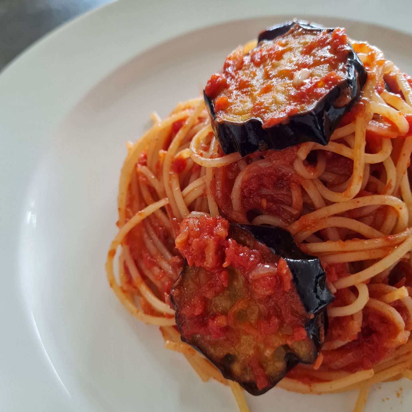 Kiki chili mix spaghetti with tomato sauce and eggplant on plate purezento for me website www.purezentoforme.com