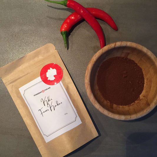 Kiki fire cacao Product packaging with chilis on table and cacaodust in wooden bowl purezento for me website www.purezentoforme.com.
